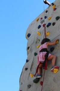 young girl on climbing wall at 2nd annual community celebration