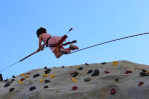 young girl repelling down climbing wall at 2nd annual community celebration