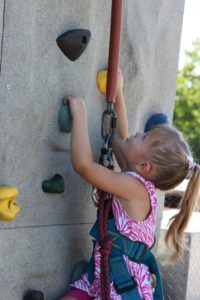 young girl on climbing wall at 2nd annual community celebration