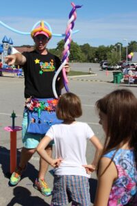 balloon man pointing at 2nd annual community celebration