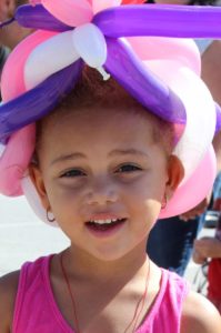 young girl with balloon hat at 2nd annual community celebration