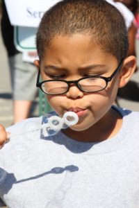 young boy blowing bubbles at 2nd annual community celebration