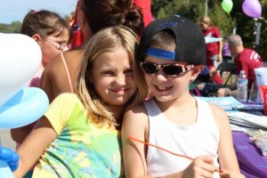 two young kids smiling at 2nd annual community celebration