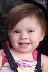 baby smiling in stroller at 2nd annual community celebration