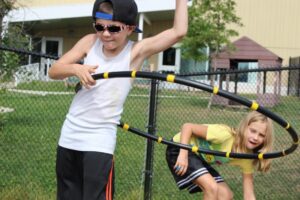 young kids playing with hula hoops at 2nd annual community celebration