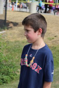 boy with cereal necklace at 2nd annual community celebration