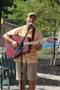 man singing with guitar at 2nd annual community celebration