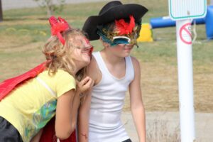 two young kids in masks at 2nd annual community celebration