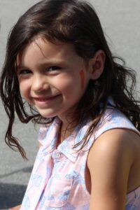 young girl smiling at 2nd annual community celebration