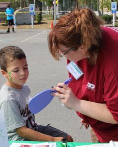 young boy viewing his face paint at 2nd annual community celebration