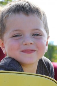 young boy smiling at 2nd annual community celebration