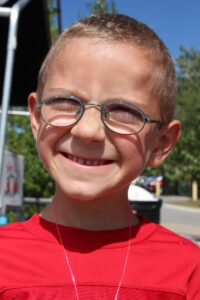 young boy smiling at 2nd annual community celebration