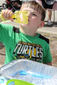 young boy blowing bubbles at 2nd annual community celebration