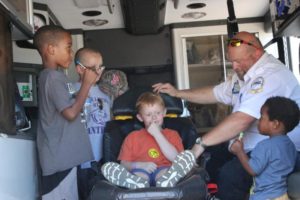 young kids hanging out in the back of an ambulance at the 2nd annual community celebration