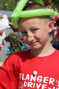 young boy in balloon hat at 2nd annual community celebration