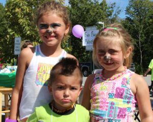 three kids with face paint at 2nd annual community celebration