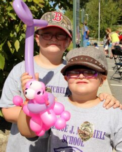 two kids with a balloon dog at 2nd annual community celebration