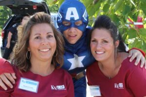 captain america with two women volunteers at 2nd annual community celebration