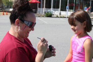 young girl getting face paint at 2nd annual community celebration