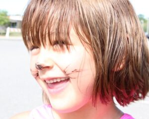 girl smiling with cat face paint at 2nd annual community celebration