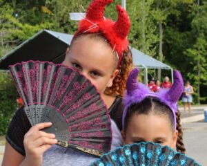 girls with devil horns and fans at 2nd annual community celebration