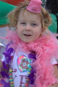 young girl in boa at 3rd annual community celebration