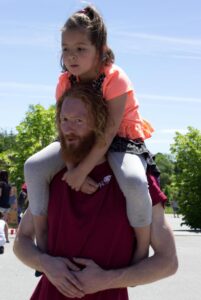 man giving piggyback ride at 3rd annual community celebration