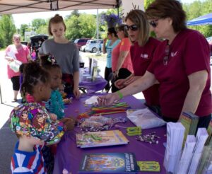 volunteers handing out treats to kids at 3rd annual community celebration