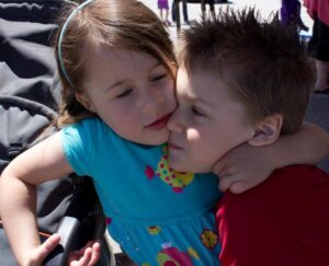 two young kids hugging at 3rd annual community celebration