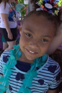 young girl smiling at 3rd annual community celebration