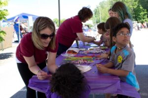 volunteers passing out treats to kids at 3rd annual community celebration