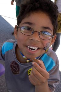 young boy eating candy at 3rd annual community celebration
