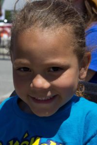 young girl smiling at 3rd annual community celebration