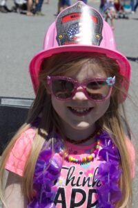 girl in pink fireman's hat at 3rd annual community celebration