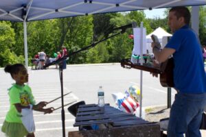 young girl and man performing music at 3rd annual community celebration