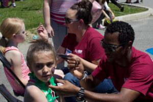 volunteers painting children's faces at 3rd annual community celebration