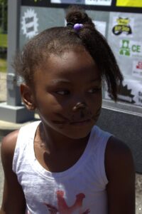 young girl in cat face paint at 3rd annual community celebration