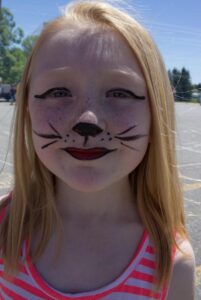 girl in cat face paint at 3rd annual community celebration