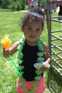 young girl holding box of raisins at 3rd annual community celebration