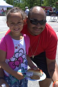 man and young girl with food at 3rd annual community celebration