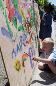 kids painting on wall at 3rd annual community celebration