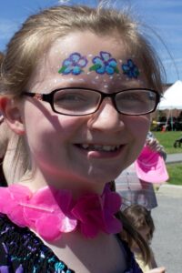 girl with flower face paint at 3rd annual community celebration