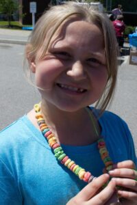 girl with cereal necklace at 3rd annual community celebration