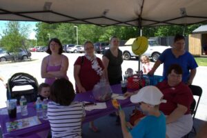 volunteers at booth at 3rd annual community celebration