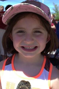 young girl smiling at 3rd annual community celebration