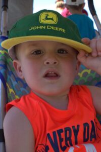 little boy in john deere hat at 3rd annual community celebration