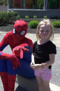 spiderman and young girl at 3rd annual community celebration