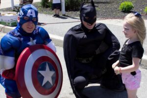 captain america, batman and young girl at 3rd annual community celebration