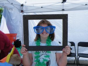 girl in photo frame enjoying 3rd annual community celebration