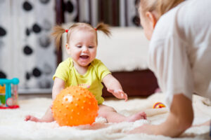 small child playing with plastic ball